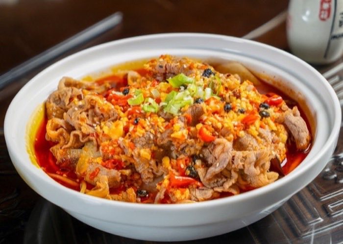 Thin sliced beef in a chili and egg broth topped with spring onion