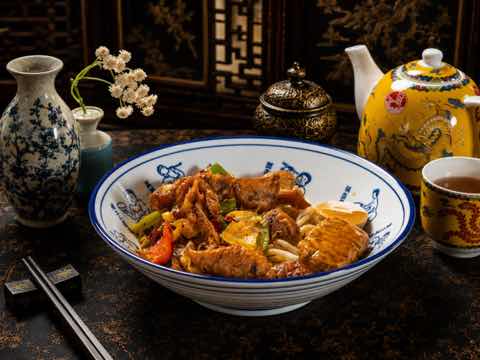 Noodle bowl with braised beef, peppers and greens