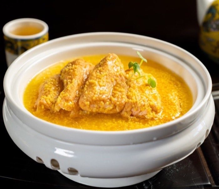 Poultry in a golden broth served in a lidded porcelain pot