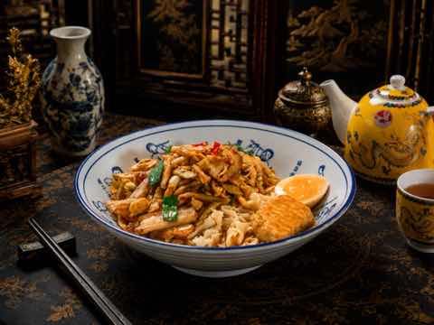 Noodle bowl with shredded chicken, greens and omelette