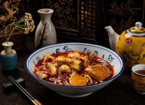 Noodles in a chili oil broth with egg and greens