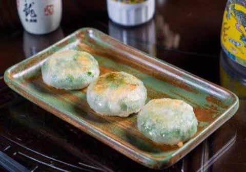 Pan-fried chive cakes on a green glazed plate