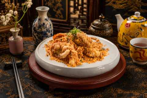 Crab tossed with golden garlic crumbs on a round stone plate