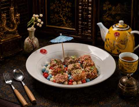 Crisp-crusted medallions plated over coloured pearls with a paper parasol