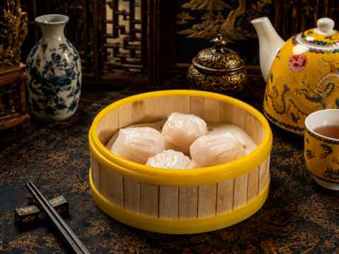 Translucent crystal shrimp dumplings in a bamboo steamer
