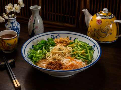 Noodles in a sesame broth with spring onion, cucumber and a crisp topping