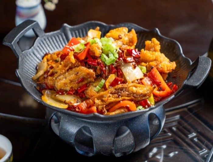 Chicken with dried chili and peppers in a cast iron dry pot