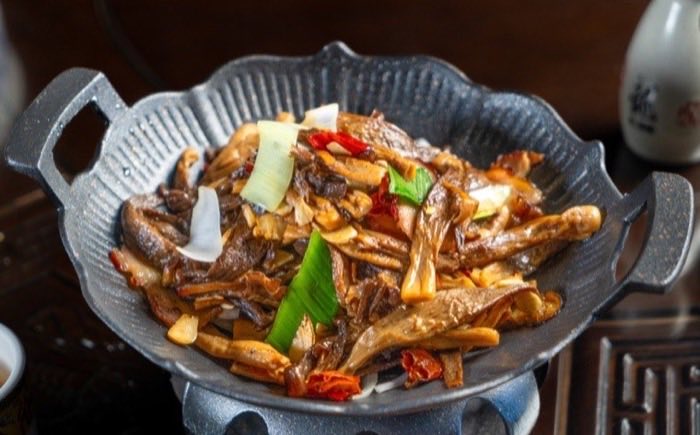 Mushrooms and dried chili tossed in a cast iron dry pot