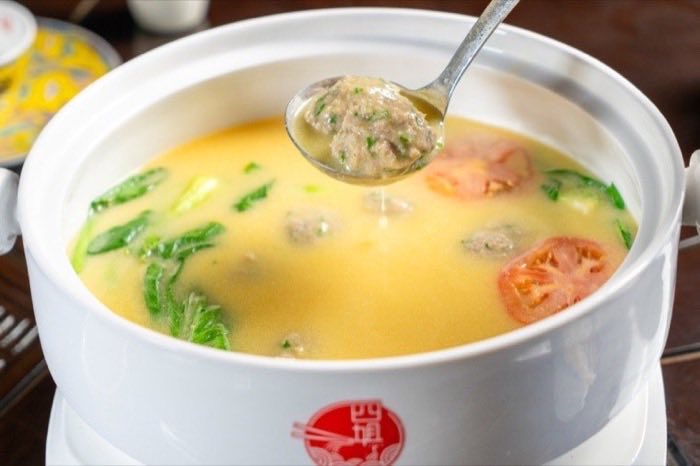 A light egg and tomato soup being lifted by the spoonful