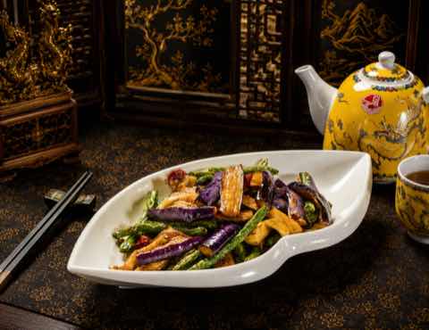 Eggplant and green beans stir-fried together on a leaf-shaped plate