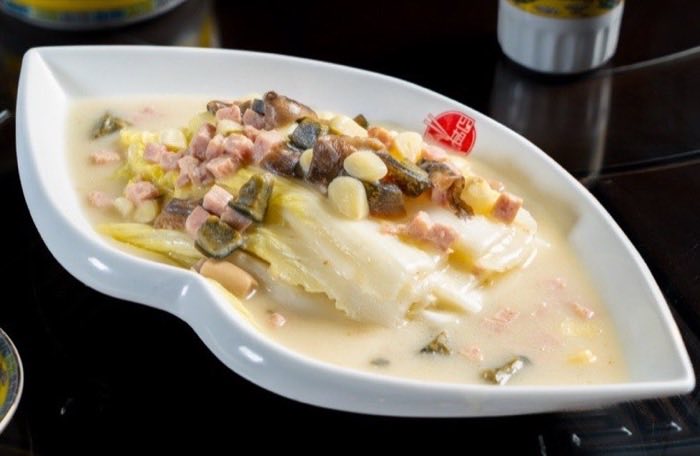 Poached fish fillet in a pale cream broth with cured ham and pickles