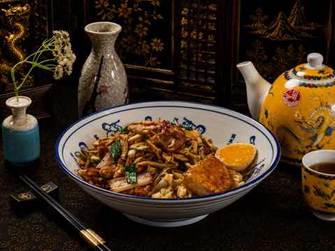 House noodle bowl with shredded meat, greens and egg