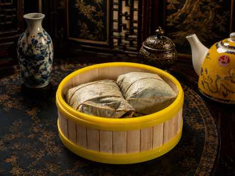 Glutinous rice parcels wrapped in lotus leaf in a bamboo steamer