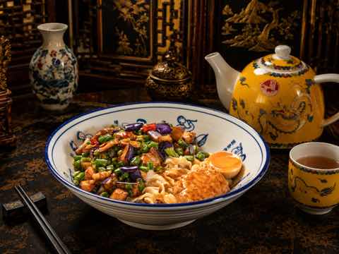 Noodle bowl with mixed vegetables, egg and a crisp topping
