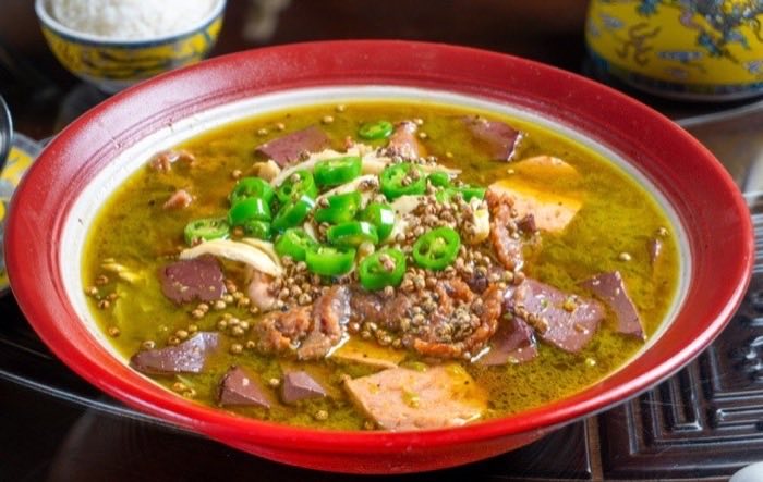 A green peppercorn broth with sliced meat and spring onion