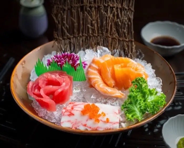 Sashimi selection presented over crushed ice with garnishes