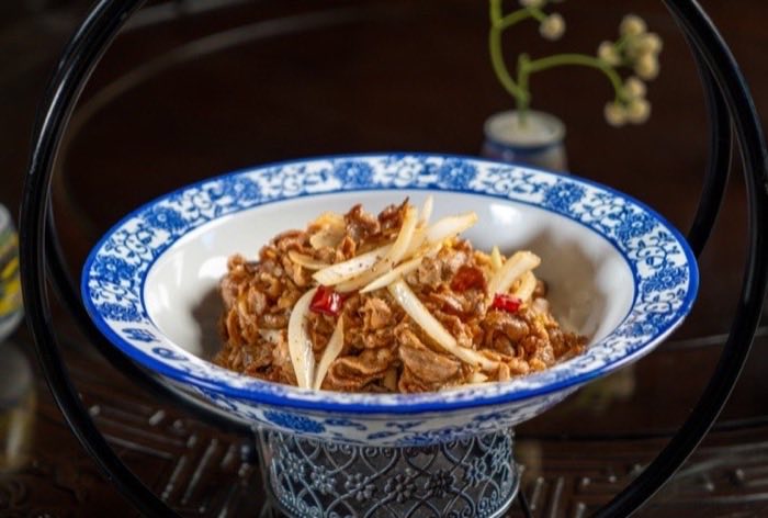 Shredded pork with bamboo shoots served in a blue and white bowl