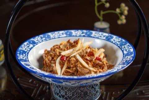 Shredded pork with bamboo shoots served in a blue and white bowl