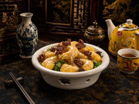 Prawns in a pale cream sauce with green peas and dark garnish