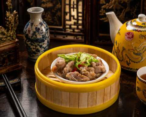 Steamed spare ribs with chili and spring onion in a bamboo steamer