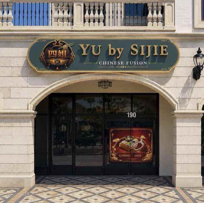 The entrance to Yu by Sijie — an arched limestone doorway beneath the green and gold restaurant sign