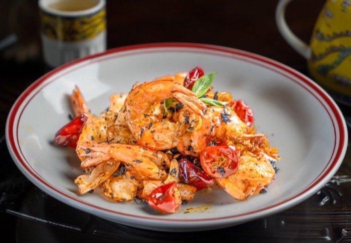 Shell-on prawns tossed with blistered cherry tomatoes and herbs