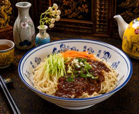 Zhajiang noodles topped with dark bean sauce, cucumber and carrot